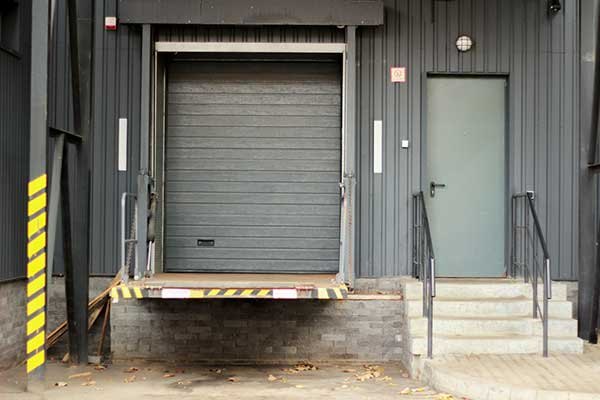 Loading dock door with dock plate